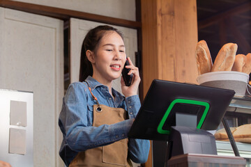 Asian barista female making hot coffee from professional machine standing behind cafe shop counter...