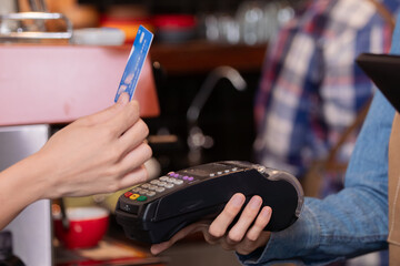 Close-up baristas or cashier worker hold payment machine accept credit card cashless transactions from customers, Smart business owner hand payment scanner to customers in cafe shop to pay for coffee