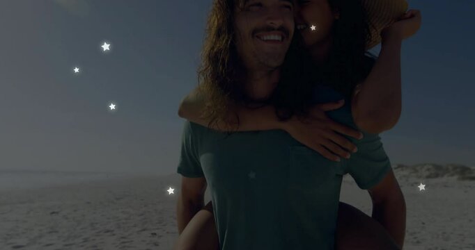 Initiating man piggybacking partner on beach her tipping straw hat stars floating for marketing