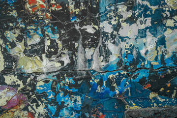 Abstraction of crumbling graffiti on a city street wall. Colorful abstract background. Old, cracked, peeling paint on the wall as a background.