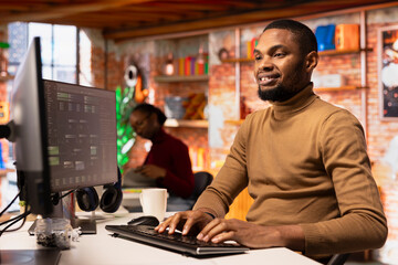 Upbeat IT engineer coding advanced AI algorithm in startup office, refining machine learning models...