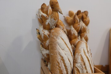 A variety of artisan breads are beautifully arranged for customers at a charming bakery. The warm tones and rustic textures invite passersby to enjoy quality baked goods. High quality 