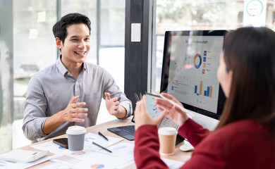 Working together on project. Two young business colleagues consulting at office