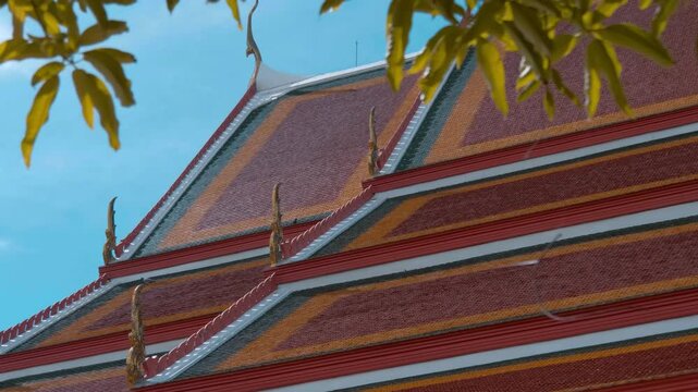 Red tiles with golden serpent-shape chofahs on the picturesque traditional Thai style roof of Wiharn Phra Mongkhon Bophit temple in Ayutthaya