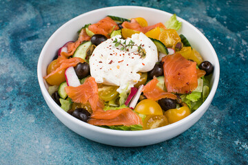 Easter brunch salad. Smoked salmon, buratta cheese, tomato, olive oil, lemon dressing salad on wooden background, top view. Flat lay
