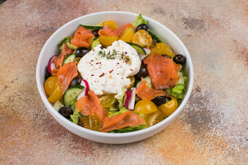 Easter brunch salad. Smoked salmon, buratta cheese, tomato, olive oil, lemon dressing salad on wooden background, top view. Flat lay