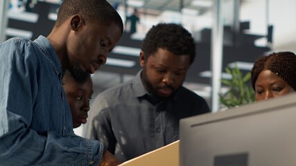 African American team collaborates on a financial planning project in a business space, emphasizing teamwork and data analysis to make informed decisions for future firm growth. Camera A.