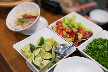 Traditional Vietnamese soup Pho bo with herbs, meat, rice noodles, broth. Pho bo in bowl with chopsticks, spoon. Space for text. Top view. Asian soup Pho bo on wooden table background. Vietnamese soup