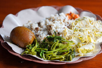 Tutug oncom rice with Sundanese vegetables, captured on May 23, 2025. Savory rice mixed with fermented soybean cake, served with fresh local greens from West Java