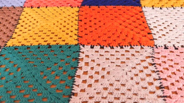 Colorful handmade crochet blanket in cozy setting