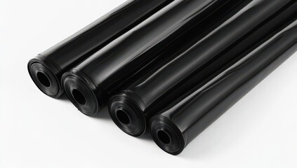 Fototapeta premium Three rolled sheets of glossy, black plastic sheeting, tightly wound and slightly overlapping on a white background