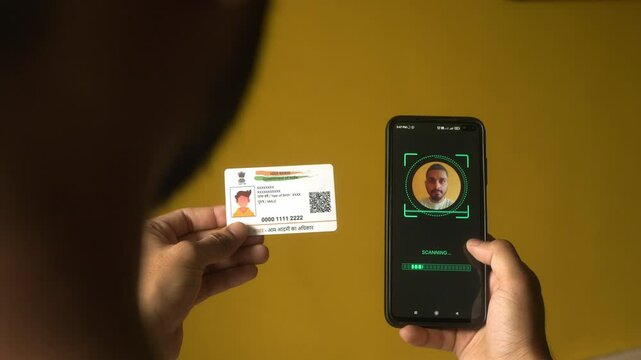 Indian nationality man scanning his face on mobile phone for eKYC digital identity verification using Aadhaar card