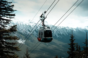 Wandcirkels Gondels A gondola floats above snowy mountains in Banff  © Viks