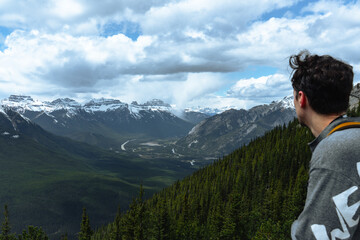 Naklejka premium A hiker admires the Rockies and river valley below.