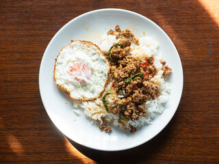 top view dish of Thai Pad Kaprao, spicy stir fried minced pork with holy basil leaves, served with rice and sunny side up