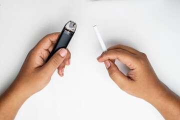 Human hand holding a cigarette, rolled tobacco in paper with a filter tube, and a vape or electronic cigarette are isolated on a white background. No or quit smoking, a bad habit, and unhealthy © Leo Lintang