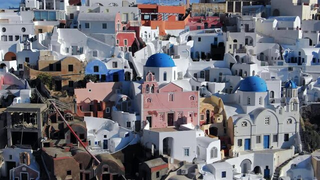 Stunning drone shot captures the enchanting scenery of Santorini island Greece, with its iconic white architecture, blue domes, and vibrant rooftops perfect destination for all travel lovers