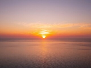 Fototapeta premium Serene Sunset Over the Ocean A Breathtaking View of Golden Hues and Calm Waters
