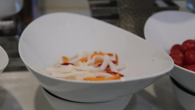 Slices of fresh peeled carrots and daikon radishes, half of unpeeled daikon radishes lie on a white table. Carrot, daikon radishes, popular ingredients in vegetable salads and snacks