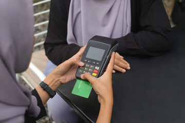 Close up of female hands making a transaction using a credit card on a point of sale machine