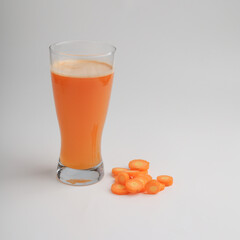 Carrot juice in a glass on white background