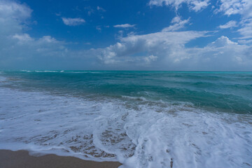 Summer beach scene. Tropical beach coastline. Exotic beach destination. Foamy beach waves. Sunny holiday.