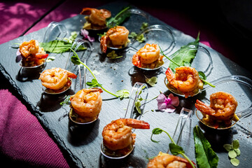 Exquisite shrimp delicacies presented artistically on a slate platter, garnished with fresh herbs