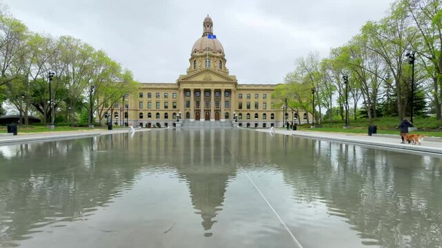 Edmonton, Alberta, Canada. May 22, 2025. The Alberta Legislature Building stands majestically, its reflection shimmering in a serene pool, symbolizing democratic stability amidst a picturesque spring 