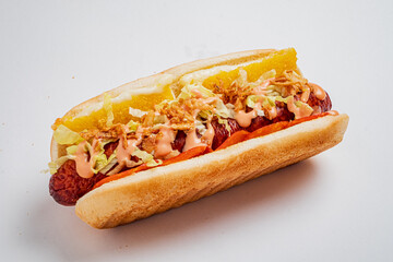 Enjoy a tasty hot dog topped with fresh lettuce, sauces, and crispy bits!