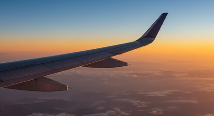 Obraz premium Airplane Wing Silhouetted Against A Golden Sunset Sky Photo