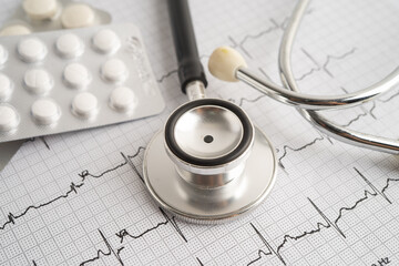 Stethoscope on electrocardiogram ECG with capsule drug, heart wave, heart attack, cardiogram report.