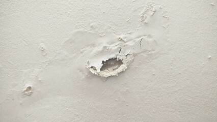 The surface or background of an old white wall with peeling paint. photo of a damp and moldy house wall