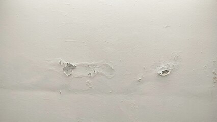 The surface or background of an old white wall with peeling paint. photo of a damp and moldy house...