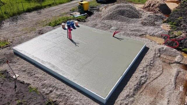 Drone Video of Freshly Poured Concrete Foundation Slab Aerial drone video showing a smooth, freshly poured concrete foundation slab at a construction