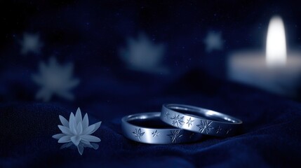 Two silver rings with star motifs on blue fabric, glowing in candlelight. A romantic symbol of love and celestial connection.