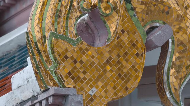 Beautiful golden chofah - traditional Thai roof decoration covered with hundreds of small golden mirrors. Shot in motion