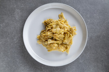 cabbage noodles served on a white plate on a grey countertop