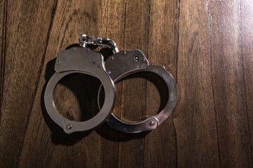 Handcuffs concept on a table with guns of different caliber