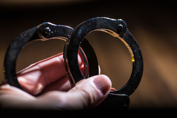 Handcuffs concept on a table with guns of different caliber