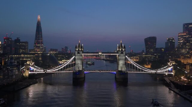 Experience Londons beauty at twilight from above, with breathtaking views of Tower Bridge and an illuminated skyline along the River Thames, capturing the citys charm in a vibrant display of colors