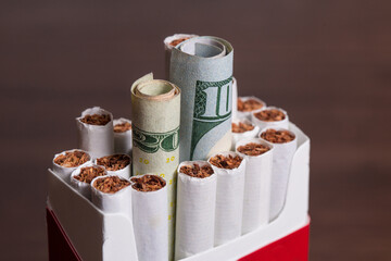 Cigarette concept inside a pack with money as in burning your money to buy drugs 