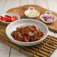 Stir fry beef with garlic, onion and chili in white plate