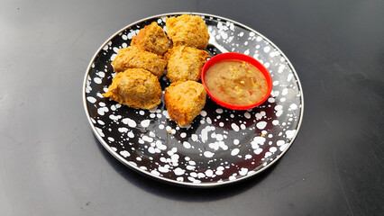 Tahu walik, tofu walik traditional Indonesian food, on a black table, aesthetic modern outdoor cafe menu, when the weather is cloudy.