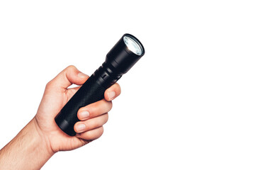 Hand holding a black led flashlight against a black background