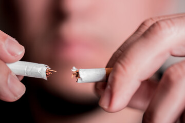 Concept image of a man cutting the habit of quitting smoking. Burning cigarette with smoke and concept of cigarettes 