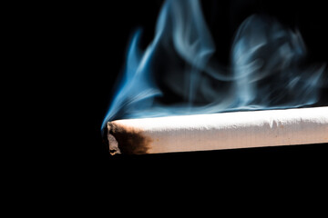 Burning cigarette with smoke and concept of cigarettes 