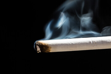Burning cigarette with smoke and concept of cigarettes 