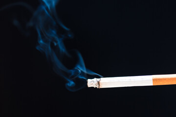 Burning cigarette with smoke and concept of cigarettes 