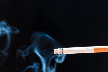 Burning cigarette with smoke and concept of cigarettes 
