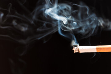 Burning cigarette with smoke and concept of cigarettes 